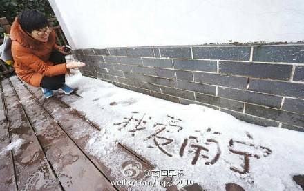 摄影爱好者爬上高处拍摄遮阳伞上的积雪