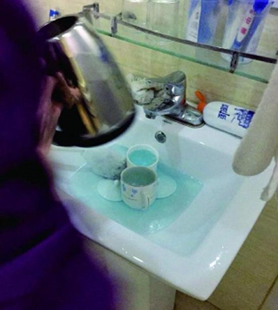 图说：酒店服务员用洁厕液刷烧水壶和茶杯。来源：北京晨报