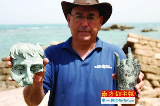 昨日，在以色列海滨城市凯撒里亚，一名以色列文物管理局的工作人员展示附近海域发现的沉船文物。