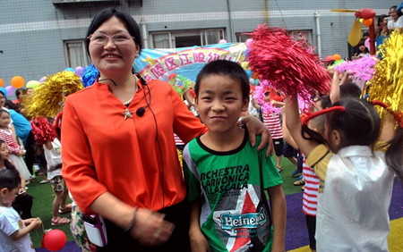 江陵幼儿园院长谭英同贫困生陈继飞合影.JPG