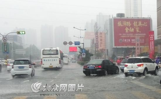 暴雨中行车，应低速档缓慢行驶，及时打开雨刮器、警示灯、防雾灯。（记者 王宗阳 摄）