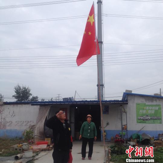 国旗升起后,赵伦波向国旗敬礼。 刘林 摄