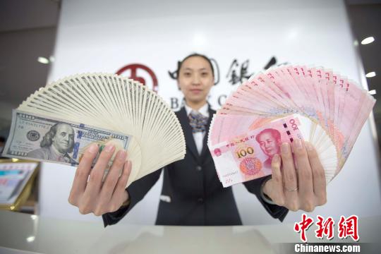山西太原，银行工作人员展示人民币、美元。张云 摄