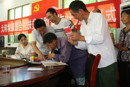 联合村贫困户在签字领取扶贫互助合作社红利。胡贵军摄.JPG