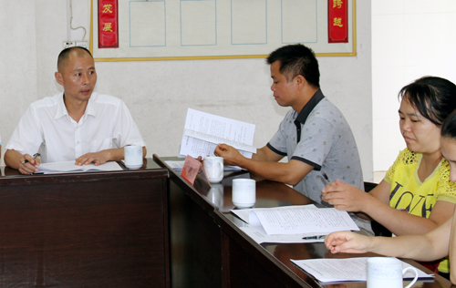 南丹县总工会副主席韦国剑(左一)在指导企业开展工资集体协商谈判.JPG