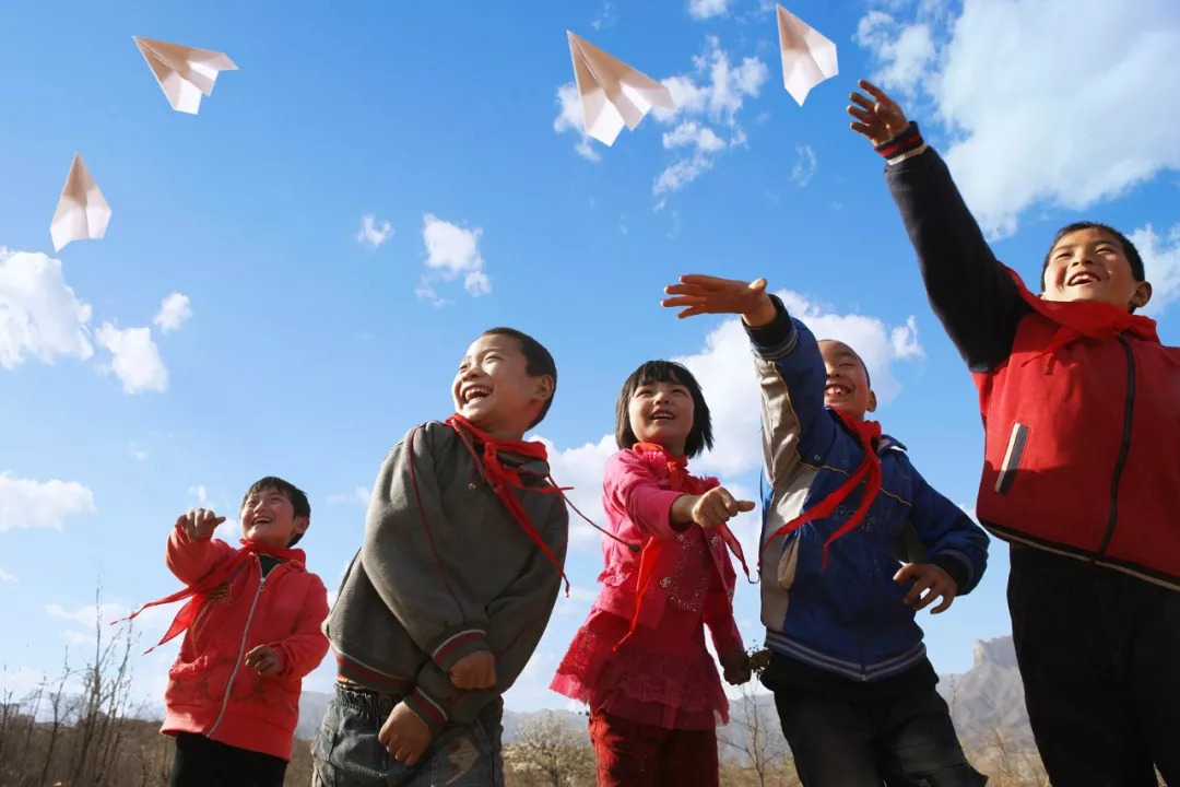 几个来自乡村小学的孩子放飞纸飞机。/ 视觉中国