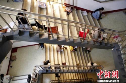 图为考研生坐在楼梯上专心背诵。孙宏瑗 摄
