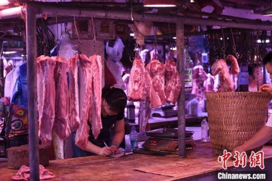 资料图为重庆一农贸市场内的商家挂满充足的猪肉。a target='_blank' href='http://www.chinanews.com/'中新社/a记者 陈超 摄