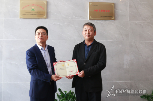 图片5图为赵荣水给张天文颁发“生态食材与生态餐馆评定委员会专家委员”证书.png