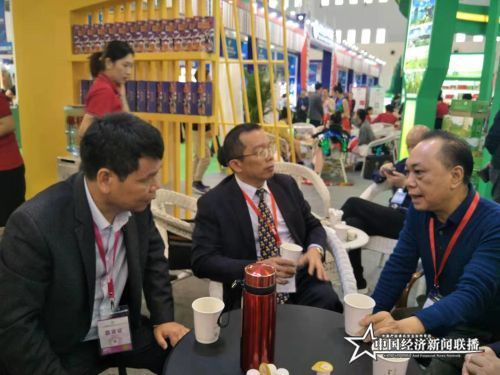 海南农垦集团党委副书记、总经理王业侨在海垦阳江农场公司展台前品尝母山咖啡。.jpg