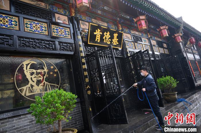 工作人员在古城里清洁店铺门面。韦亮 摄 工作人员在古城里清洁店铺门面。韦亮 摄