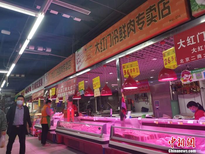 图为北京某菜市场里的猪肉摊。 谢艺观 摄 图为北京某菜市场里的猪肉摊。 谢艺观 摄