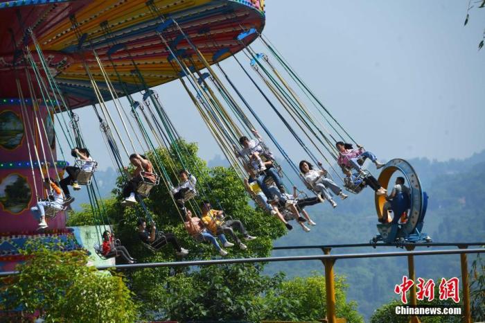 5月1日，“五一”节假的第一天， 重庆涪陵红酒小镇景区内的游客乘坐体验游乐设施。a target='_blank' href='http://www.chinanews.com/'中新社/a记者 陈超 摄