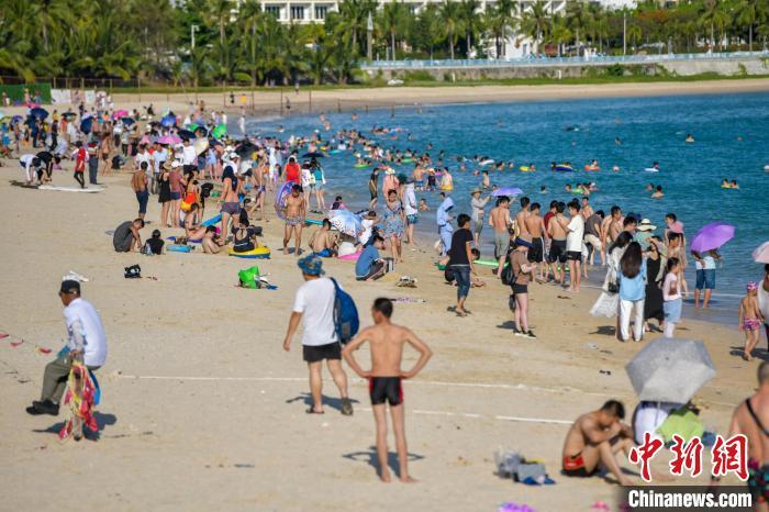 资料图：众多游客在三亚大东海旅游景区海滩享受碧海蓝天。 骆云飞 摄