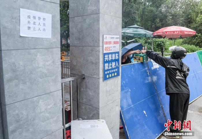 7月29日，北京新增确诊病例所在的居民小区已封闭，外卖人员向小区内递送居民购买的生活用品。 a target='_blank' href='http://www.chinanews.com/'中新社/a记者 贾天勇 摄