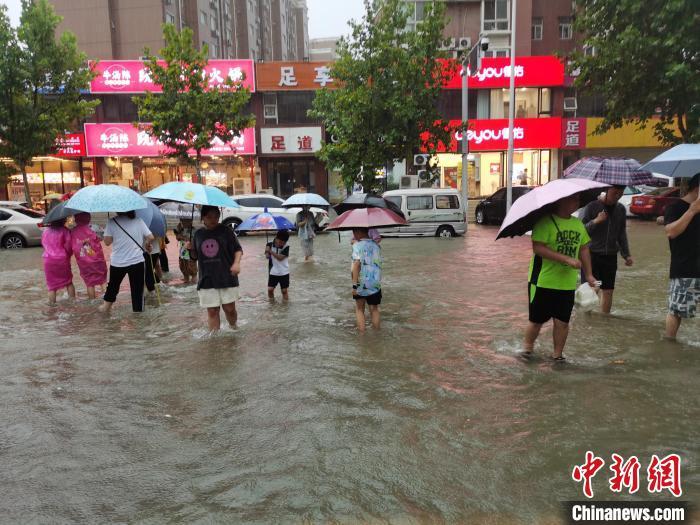 资料图:郑州7·20特大暴雨后,市民在街道上趟水而过。王登峰 摄 资料图:郑州7·20特大暴雨后,市民在街道上趟水而过。王登峰 摄