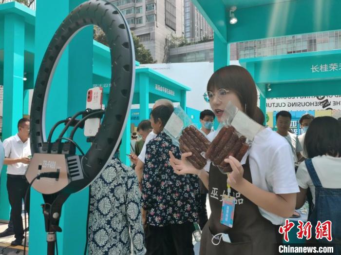 图为“巫姑腊味”展区工作人员正在直播。袁子寒 摄 图为“巫姑腊味”展区工作人员正在直播。袁子寒 摄