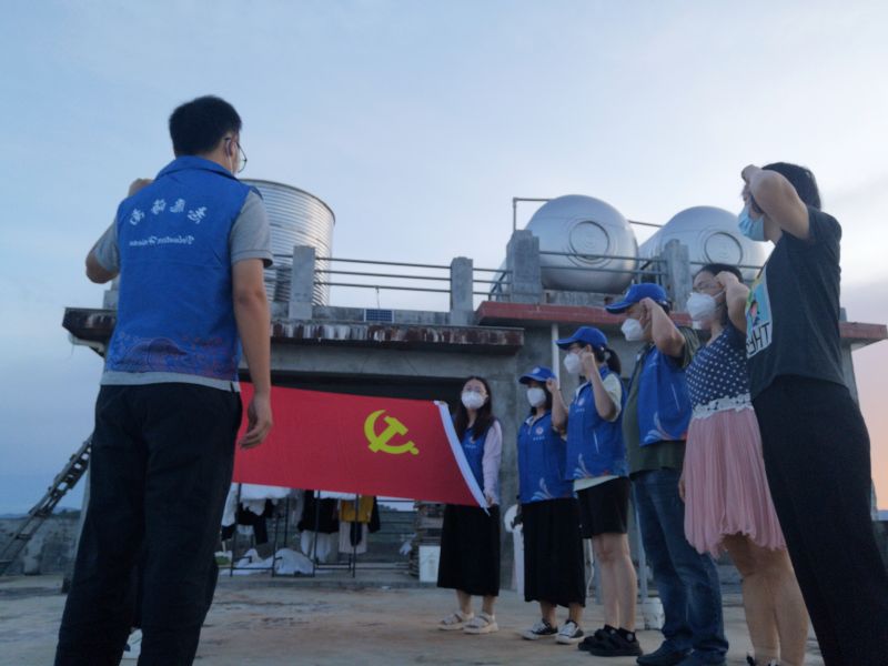 党员志愿者们在党旗前重温入党誓词.jpg