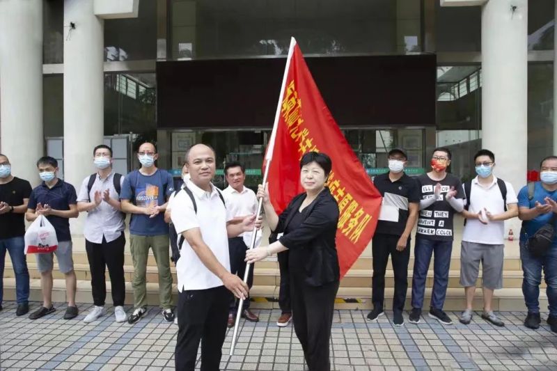 学校党委副书记(主持党委工作)许玫为第三批志愿服务队授旗送行.jpg